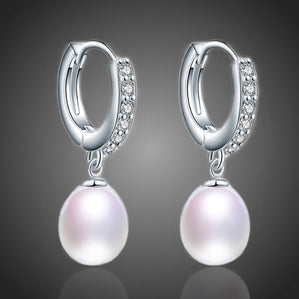 náušnice visiace s bielymi riečnymi perlami